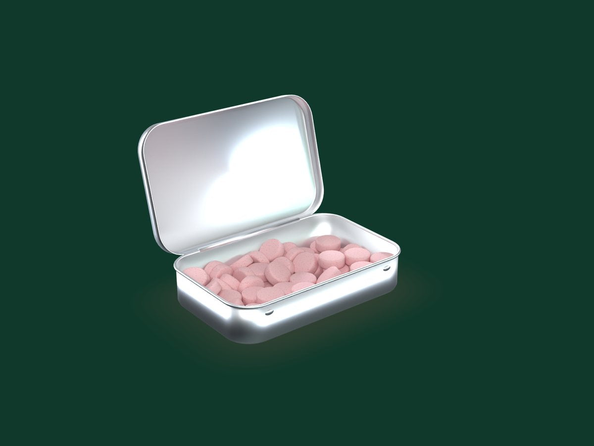 An open tin filled with strawberry caffeinated mints